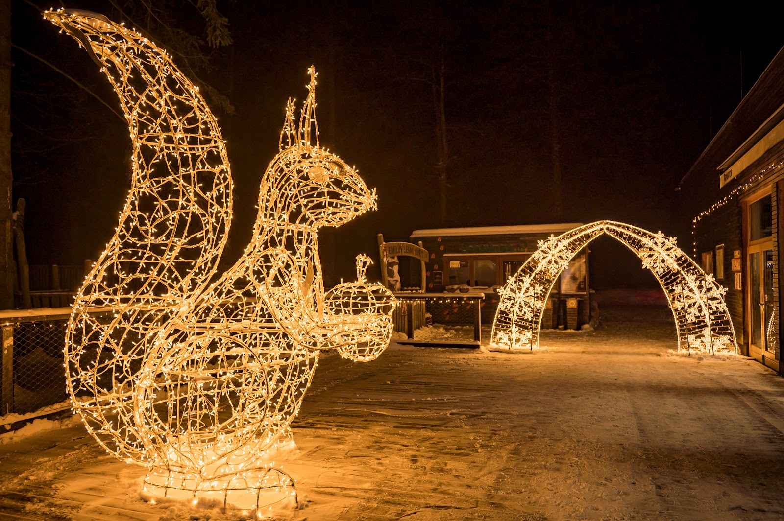 Venkovní vánoční světelné dekorace s rovnou zpevněnou cestou vhodnou pro kočárky.